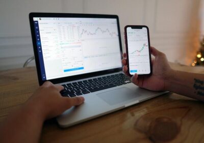 Blog Macbook and phone displaying graphs on wooden table